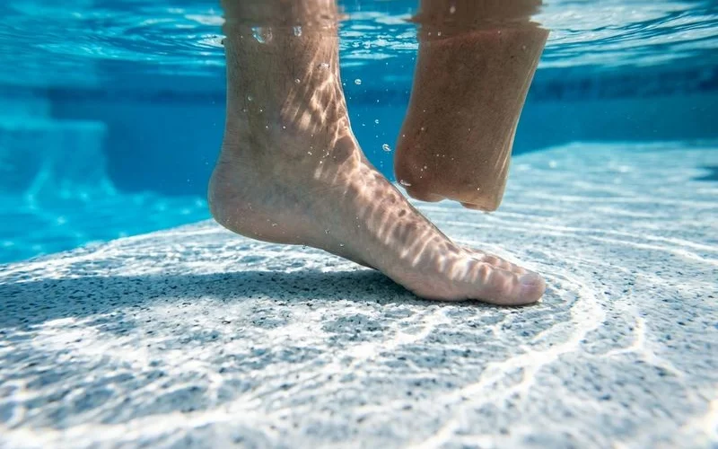 Foot entering pool water on Diamond Brite — smooth feel